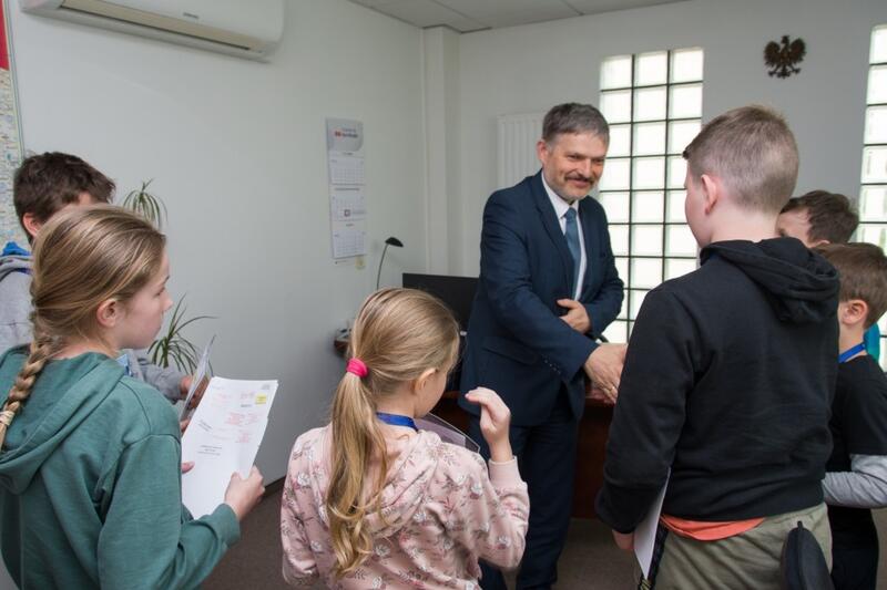 Powiększ obraz: Dyrektor Urzędu Statystycznego podający rękę dzieciom