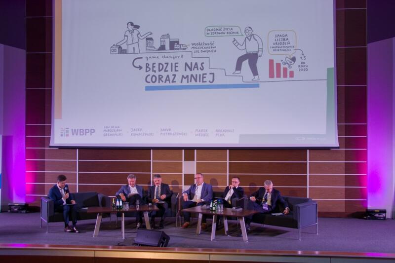Powiększ obraz: Uczestnicy panelu i infografika na ekranie
